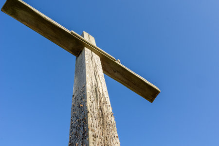 Low angle view of large wooden cross in field an remains of historic altar at St Benet's Abbey in Norfolk Broads United Kingdom.の写真素材