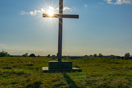 Wooden cross on historic site of Benedictine Abbey of St Benets in Norfolk Broads back-lit by late afternoon sun now with a slight lean.の写真素材