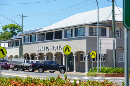 Grafton Australia - February 5 2026; Grafton Hotel on city intersection with bright yellow pedestrian crossing  signs and gardens.のeditorial素材