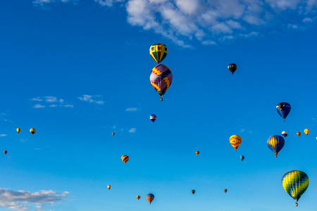 Hot Air Balloons fly over the city of Albuquerque, New Mexico during the mass ascension at the annual International Hot Air Balloon Fiesta in October, 2016の写真素材