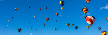 Hot Air Balloons fly over the city of Albuquerque, New Mexico during the mass ascension at the annual International Hot Air Balloon Fiesta in October, 2016の写真素材