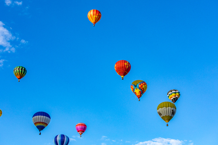 Hot Air Balloons fly over the city of Albuquerque, New Mexico during the mass ascension at the annual International Hot Air Balloon Fiesta in October, 2016の写真素材
