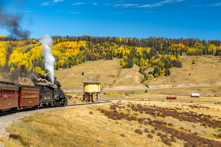 A Cumbres & Toltec steam locomotive slows down for a water stop on a trip  from Chama, New Mexico through a beautiful scenic mountain route ending in Antonito, Coloradoのeditorial素材