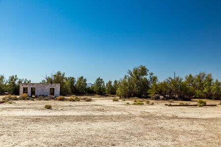 An abandoned building sits alongside the roadway near Death Valley Junction in the Funeral Mountains Wilderness Area, California.の写真素材