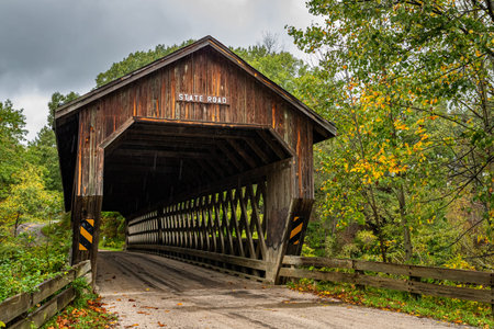 The State Road Covered Bridge crosses the West Branch of Conneaut Creek during the Autumn leaf color...