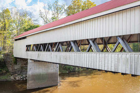 The Mechanicsville Covered Bridge crosses Grand River during the Autumn leaf color change in...
