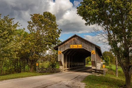 The Caine Road Covered Bridge crosses the Ashtabula River during the Autumn leaf color change in...