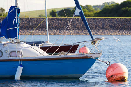Small sailing boats on a mooring ball.の写真素材