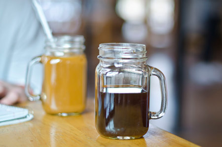 Two coffees in mason jars at the local coffee shop studying for the next test.の写真素材