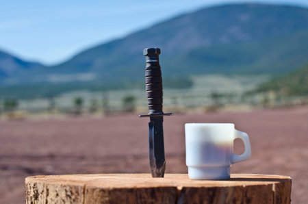A k bar knife on display with the morning coffee in the summer desert sun.