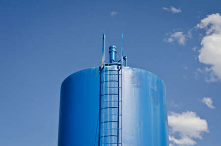A solo blue water tanker in the blue sky on a nice summer day.の写真素材