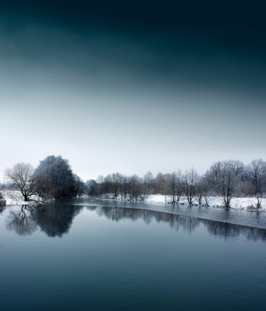 Winter Landscape with Calm River and Trees over Water  Copy space の写真素材