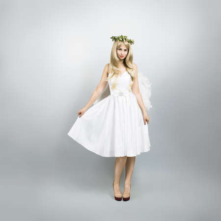 Blonde Woman in Fancy Costume of Angel on Gray for Copy Space の写真素材