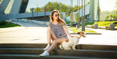 Hipster Fashion Girl with her Dog in the City. Modern Youth Lifestyle Concept. Wide Format Perfect for Website Header or Slider.の写真素材
