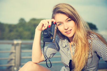 Portrait of Beautiful Hipster Girl with Vintage Camera. Modern Youth Lifestyle Concept. Toned Photo...