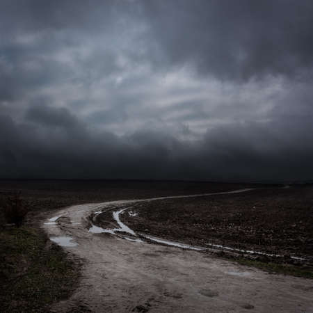 Night Landscape with Country Road and Dark Clouds. Moody Sky .