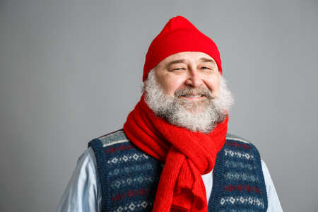Portrait of Happy Old Man with Beard in Winter Clothes on Gray Background. Modern Mature Man Concept. Copy Space.の写真素材