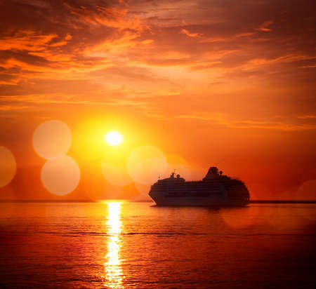 Silhouette of Cruise Ship at Sea. Beautiful Seascape Sunset Background. Romantic and Luxury Travel Concept. Toned and Filtered Photo with Bokeh. Copyspace.の写真素材