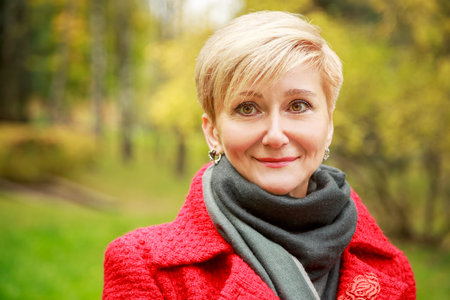 Portrait of Smiling Middle Aged Woman on Autumn Background. Elegant Happy Fashion Woman Outdoors....
