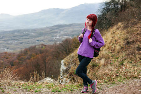 travel girl with red hair backpack mountainの写真素材