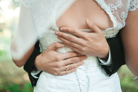 Wedding couple holding hands and hugging body partの写真素材