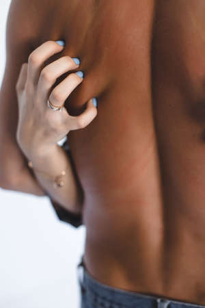 Woman's hand scratching down man's bare back isolated over white backgroundの写真素材