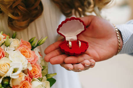 bride and groom holding a ring boxの写真素材