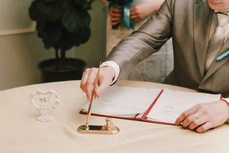 the groom signs the documents in the registry officeの写真素材