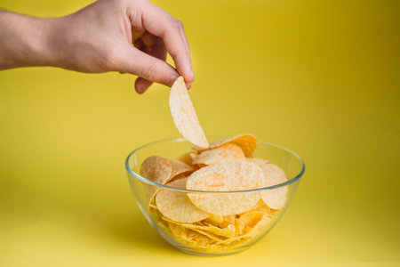 plate of chips unhealthy food on yellow color background