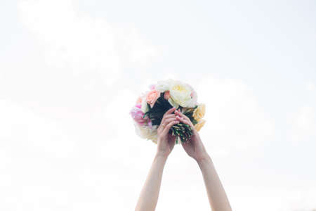 Bride's bouquet in her hands. Beautiful wedding bouquet in hands of a bride. Selective focus. Young bride holding the wedding bouquetの写真素材
