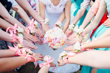 Bride's bouquet in her hands. Beautiful wedding bouquet in hands of a bride. Selective focus. Young bride holding the wedding bouquetの写真素材