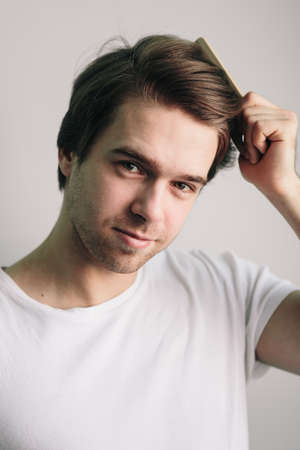 man with healthy hair holding comb. clean healthy man's hair without furfurの写真素材