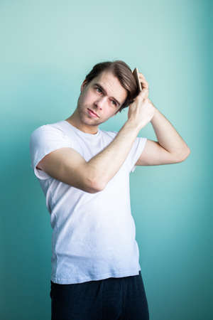 Combing hair. Morning of a young man.の写真素材