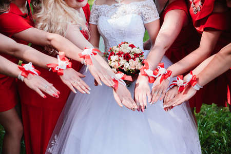 The bride and bridesmaids are showing beautiful flowers on their hands.の写真素材