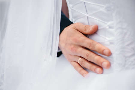 The bridegroom at the wedding walk gently hugs the bride's waist. Wedding.の写真素材
