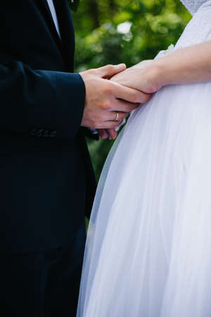 bride and groom holding hands on walkの写真素材
