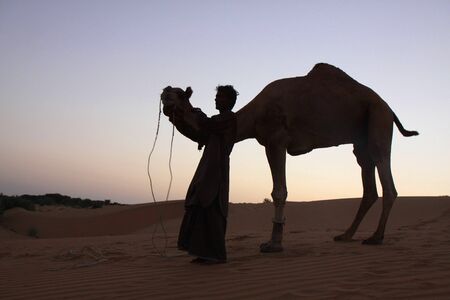 Thar Desert, Rajasthan, India - November, 2010 - A camel guide poses for photos with his camel.のeditorial素材