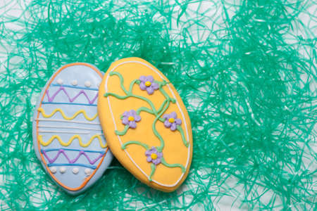 Easter Cookies in the Shape of an Egg Decorated with Blue and Yellow Frostingの写真素材