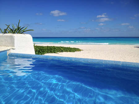 Infinity Pool Overlooking White Sand Beach With Turquoise Seaの写真素材