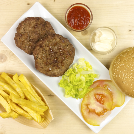 Hamburgers in a plate on wooden background - top viewの写真素材