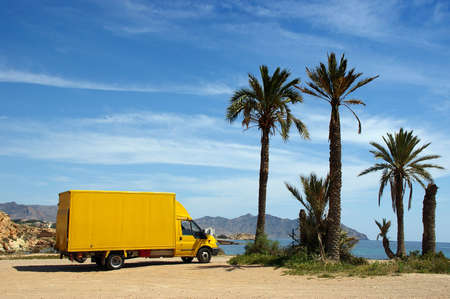 yellow van near palm trees & beachの写真素材