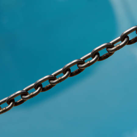 dark iron chain with blue backgroundの写真素材