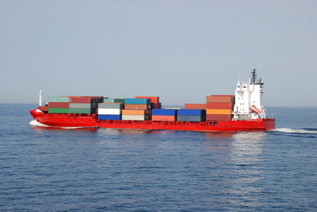 Long Cargo Ship Transporting Sea Containers Full of Goodsの写真素材