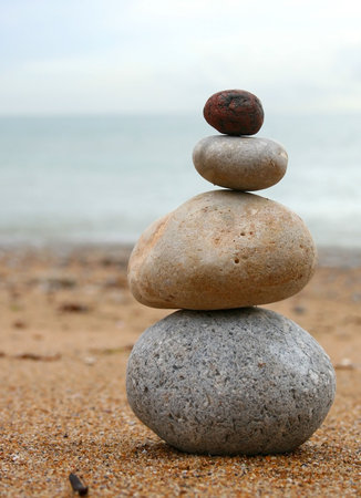 4 stones stacked up on beach