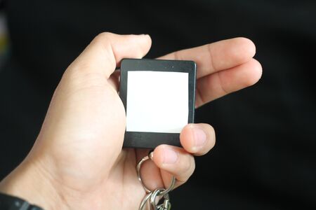 hand holding a keychain or small frameの写真素材