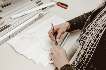 Woman worker assembles aluminum blinds at the factory by hand.の写真素材