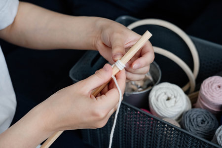 Weaving macrame at home. Hand of a woman when she is making macrame.