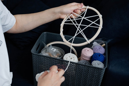 Weaving macrame at home. Hand of a woman when she is making macrame.