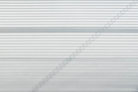 The light from the window falls on the wall, the shadow lines from the blinds.の写真素材