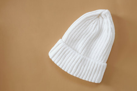White hat for a newborn for walking in autumn or spring on a beige background. Clothes for newborns.の写真素材